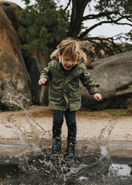 Child Jumping Into Puddle
